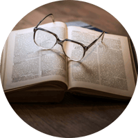 Brille auf ein offenes Buch gesetzt